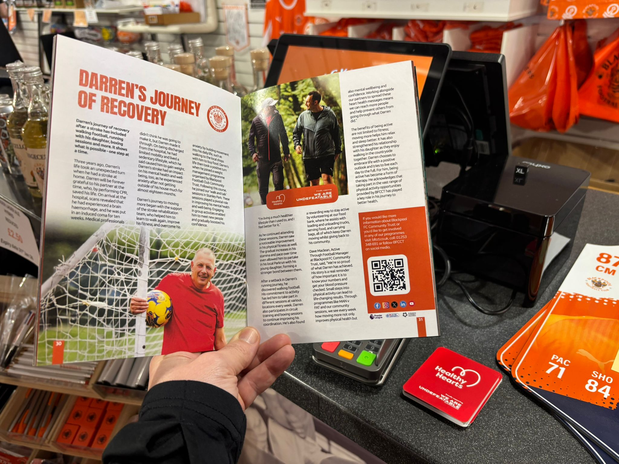 Someone holding the Blackpool FC match day programme, open to show Darren's story featured.
